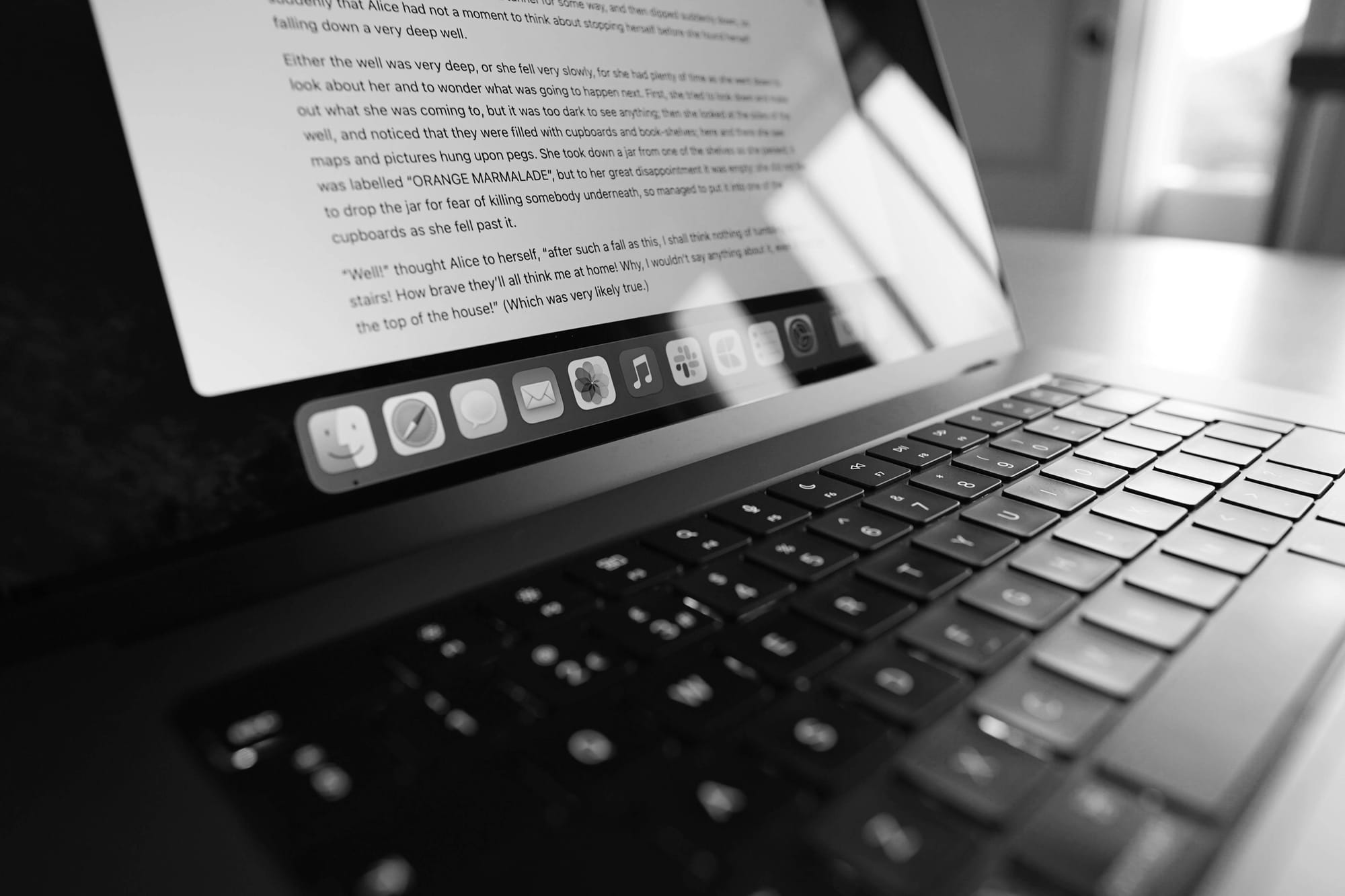 A laptop keyboard and screen photographed close up in black and white