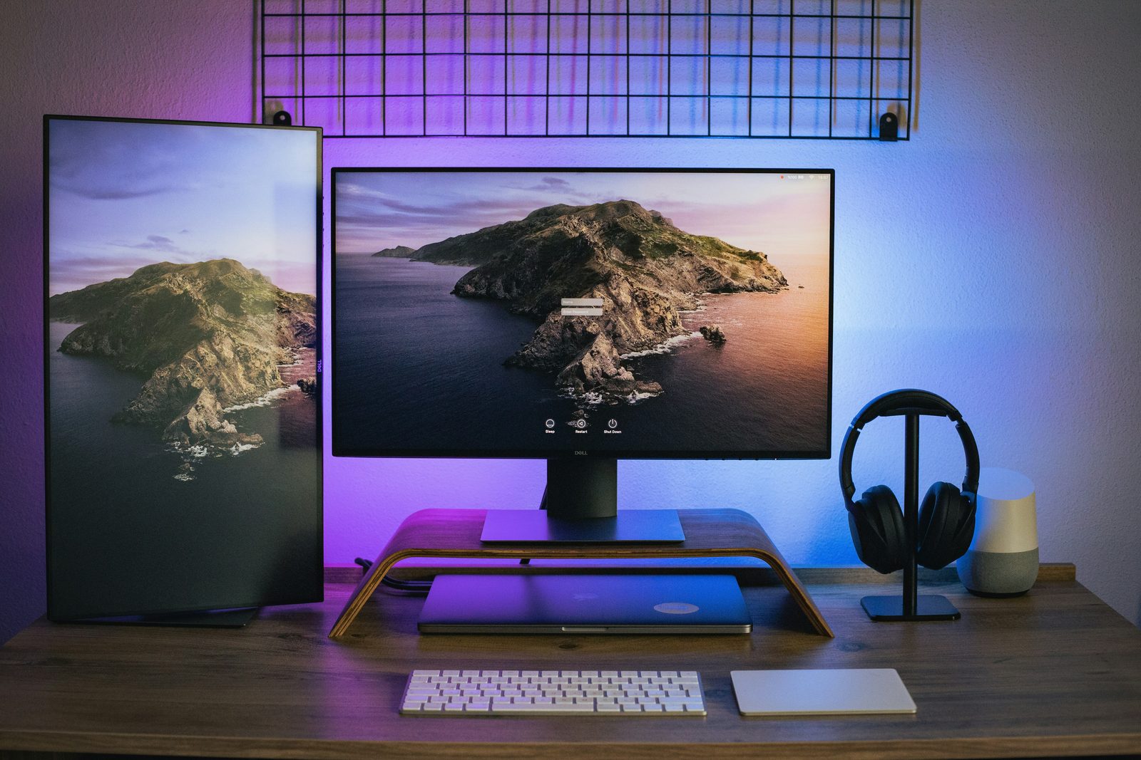 A desk setup with two monitors showing a mountain coastline wallpaper