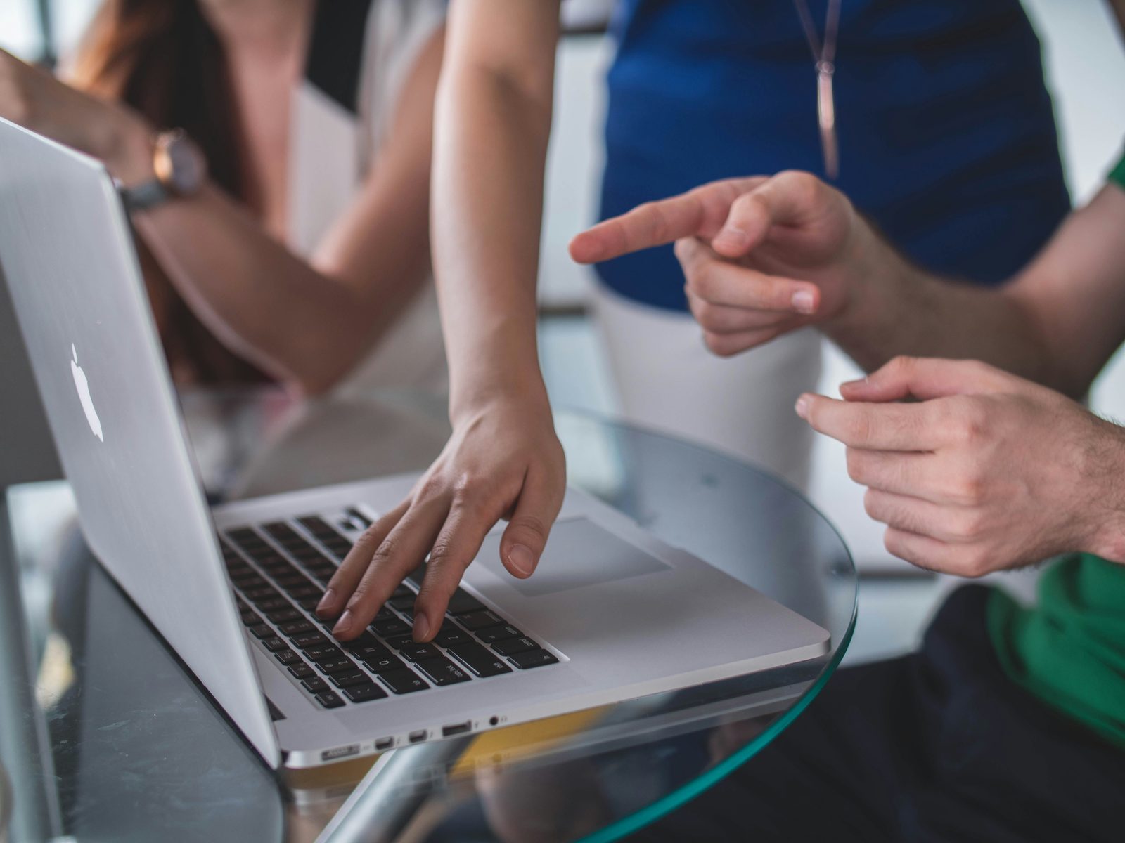 Two people at a laptop, one pointing while the other types