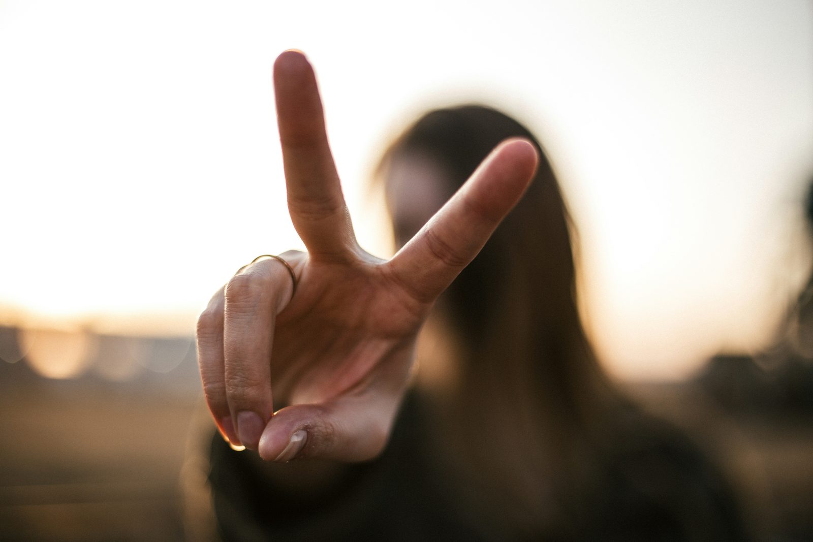 A hand held up against the evening sun, holding up two fingers
